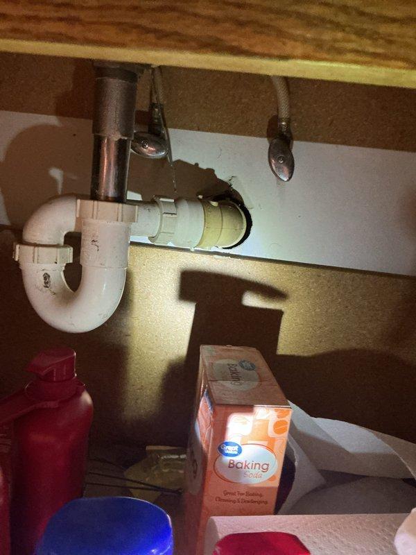 Completed comprehensive plumbing inspection of residential property with homeowner absent. Evaluated multiple fixtures and systems throughout the home, identifying several aging components including kitchen sink plumbing with older PVC P-trap configuration and discolored copper supply lines with shut-off valves, as well as a white cylindrical water heater showing signs of age with standard copper piping connections. Documented conditions via photographs and prepared replacement estimates for outdated fixtures and appliances requiring updating.
