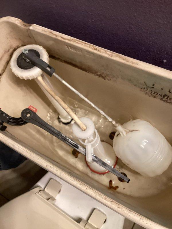 Responded to service call for continuously running toilet. Upon inspection, discovered loose flush valve assembly under tank causing leak, along with faulty ball cock mechanism. Replaced complete flush valve assembly, ball cock fill valve, and flush handle to resolve running water issue. Significant water accumulation observed on bathroom floor, attributed to combination of prolonged toilet operation, tank condensation, and leaking tank bolts—pre-existing conditions prior to service arrival. All components tested and functioning properly upon completion.