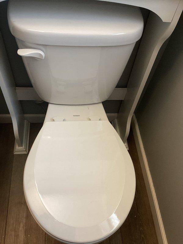 Responded to follow-up service call for leaking downstairs toilet with leak occurring between tank and bowl. Upon inspection, identified multiple deficiencies with existing toilet fixture that would require extensive repairs. Presented repair options versus replacement to customer. Customer elected to proceed with complete toilet replacement. Removed old toilet fixture and installed new white porcelain gravity-flush toilet with standard left-side flush lever. Ensured proper sealing between tank and bowl, verified secure mounting to floor flange, and tested for leaks. Confirmed proper flush operation and water fill cycle upon completion.