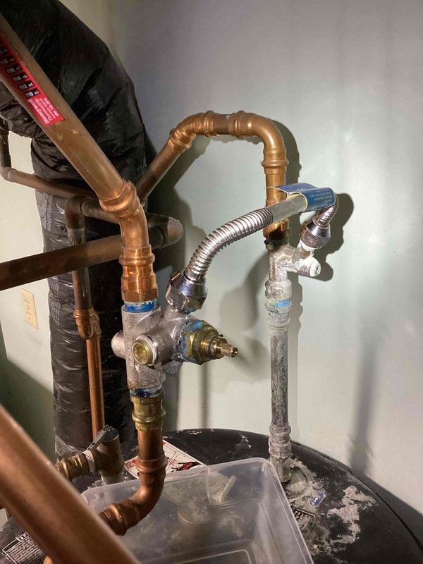 Responded to no heat and no hot water complaint on residential boiler system installed in 2020. Upon arrival, found boiler not firing and multiple water leaks present in the system. Diagnosed leaking shut-off valve on auto-fill system; isolated valve to stop active leak. Identified leaking ball valve at circulator pump, tightened compression nut to eliminate leak. Auto-fill system found to be non-functional, preventing proper system pressurization. Manually added water to boiler to restore proper operating pressure. Successfully started system and verified boiler ignition and proper operation of all components. Located additional leak at fitting above water heater requiring specialized part not currently in stock. System restored to full operation with temporary repairs holding. Provided estimates for permanent repairs including replacement of auto-fill shut-off valve and auto-fill assembly to prevent recurrence. Parts order submitted for water heater fitting repair. System operational