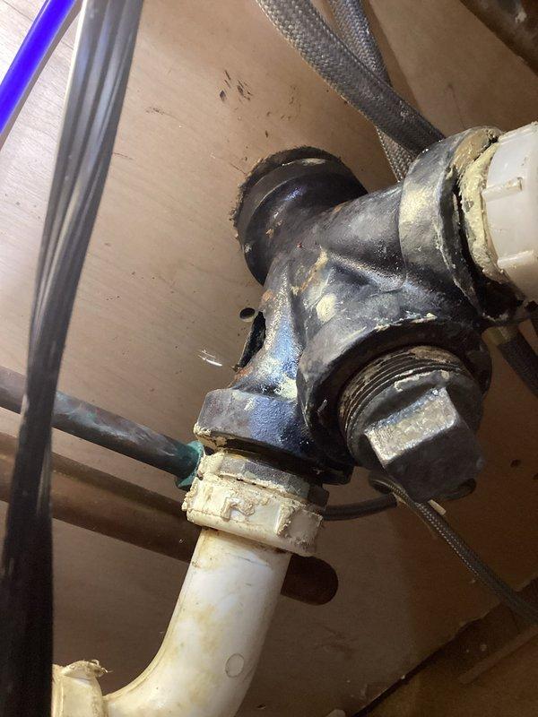 Responded to kitchen sink drain leak caused by corroded cast iron pipe with visible hole in the line. Removed deteriorated cast iron piping from under kitchen sink and installed new PVC drain line connecting to existing basement stack. Replaced compromised drain assembly with code-compliant materials, ensuring proper slope and secure connections throughout the drainage system.