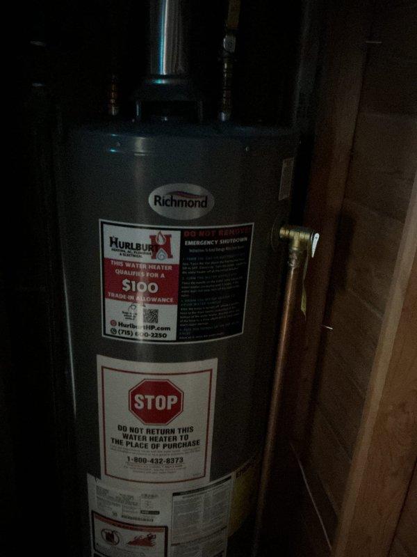 Completed comprehensive plumbing inspection of residential property. Inspected Richmond brand water heater installation, verifying proper copper pipe connections, brass fittings, and safety labeling compliance. Evaluated bathroom plumbing fixtures including handheld shower assembly with chrome filter attachment and water supply connections, noting all components functioning within normal parameters with minor observations documented.