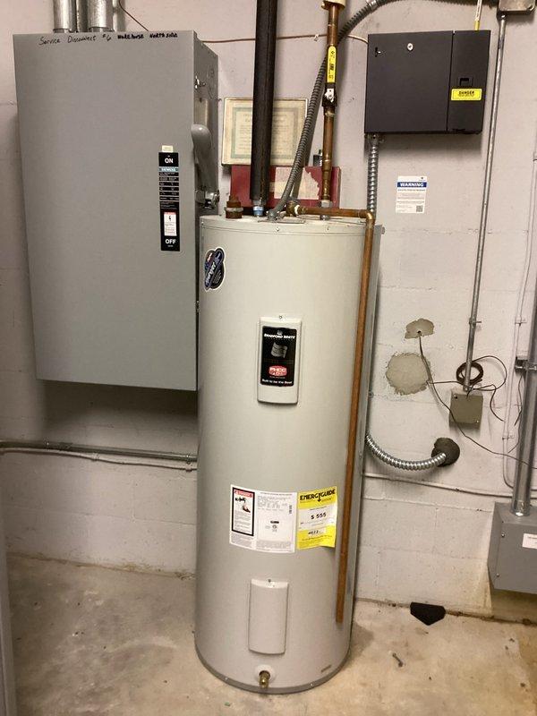 Responded to commercial facility reporting no hot water at multiple points throughout the building. Upon arrival, performed diagnostic assessment of Bradford White tanked water heater located in riser room. Found unit currently operational and producing hot water, though previous element replacement occurred approximately 6-7 years ago and overall unit age is unknown. Documented existing 50-gallon water heater system with associated copper piping, filtration equipment, and electrical service connections. Verified hot water delivery restored to building. Photographed installation for assessment and recommended future water heater replacement due to age and history of heating element failure.