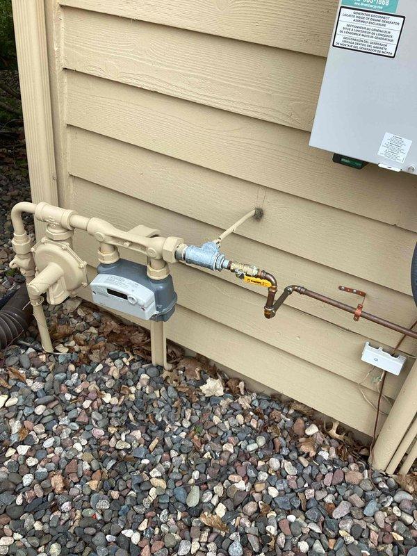 Responded to gas odor complaint near exterior generator installation. Upon arrival, utility company had already identified two gas leaks on supply lines. Removed and replaced defective fitting at tee connection, eliminating first leak. Tightened loose gas connection at generator inlet to resolve second leak. Performed comprehensive leak verification using combustible gas meter and soap solution on all connections. Confirmed system returned to safe operating condition with no detectable leaks present.