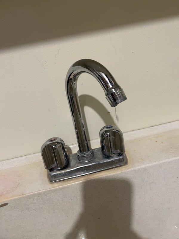 Replaced leaking laundry tub faucet with new chrome fixture after existing faucet exhibited continuous dripping. Removed and replaced both shut-off valves (stops) that were seized and non-functional, along with deteriorated supply lines that were actively leaking. All new components installed and tested for proper operation with no leaks detected.