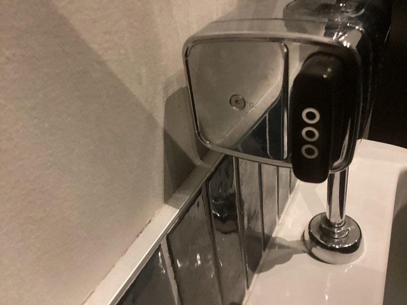 Responded to emergency call for overflowing wall-mounted urinal in commercial restroom facility. Upon arrival, confirmed water supply had been shut off to prevent further leaking. Performed diagnostic assessment and identified blockage in urinal drain line caused by mineral buildup and debris accumulation. Utilized drain cable equipment to clear obstruction from the line, restoring proper drainage and flow. Tested flush valve operation and verified complete clearance of blockage. Restored water supply and conducted final operational test to ensure urinal was functioning properly without leaks.