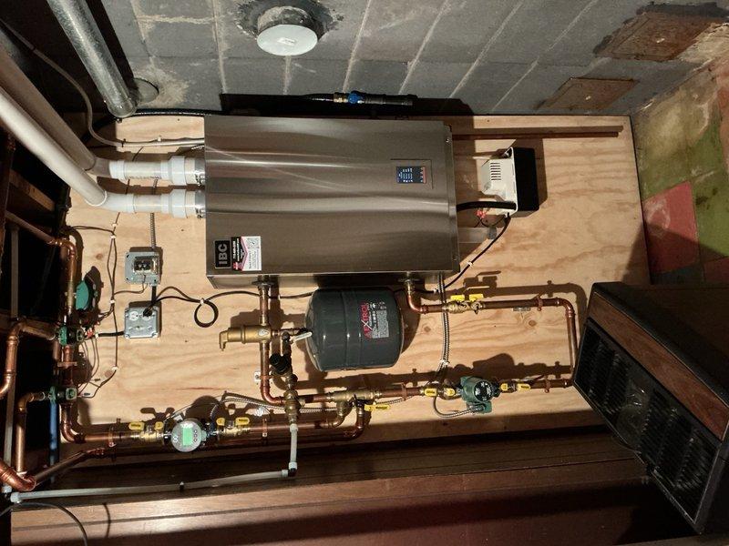 Responded to no heat call on residential boiler system. Upon arrival, found boiler shut down due to low water pressure condition. Discovered auto fill valve was closed and system pressure had dropped below operating threshold. Attempted to restore water feed but found backflow preventer and auto fill assembly were seized and not functioning properly. Disassembled and freed both components to restore water flow to system. Successfully brought boiler pressure up to proper operating level, at which point unit fired and resumed normal heating operation. 

However, noted relief valve on backflow preventer was dripping following restoration of water pressure. Placed collection bucket beneath drip and advised homeowner of condition. Given that system is only two years old, prepared estimates for replacement of backflow preventer as standalone repair, as well as combination replacement of both backflow preventer and auto fill assembly. Submitted parts inquiry to verify potential warranty cover