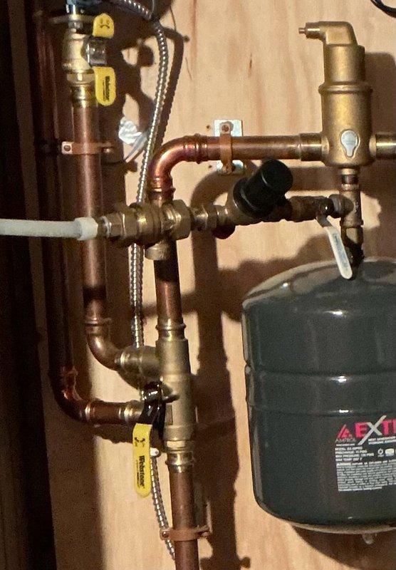 Responded to no heat call on residential boiler system. Upon arrival, found boiler shut down due to low water pressure condition. Discovered auto fill valve was closed and system pressure had dropped below operating threshold. Attempted to restore water feed but found backflow preventer and auto fill assembly were seized and not functioning properly. Disassembled and freed both components to restore water flow to system. Successfully brought boiler pressure up to proper operating level, at which point unit fired and resumed normal heating operation. 

However, noted relief valve on backflow preventer was dripping following restoration of water pressure. Placed collection bucket beneath drip and advised homeowner of condition. Given that system is only two years old, prepared estimates for replacement of backflow preventer as standalone repair, as well as combination replacement of both backflow preventer and auto fill assembly. Submitted parts inquiry to verify potential warranty cover