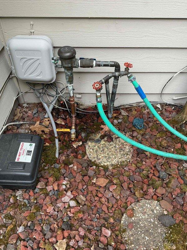 Responded to follow-up appointment for outdoor irrigation system leak. Upon inspection, identified a pinhole leak in three-quarter inch copper waterline caused by grounding clamp damage just after the pipe exited the building. The grounding clamp had created pressure and corrosion on the copper pipe, resulting in water seepage at the sprinkler system's manifold area. Performed repair of the damaged three-quarter inch waterline section, replacing the compromised copper pipe segment and ensuring proper clearance from the grounding clamp to prevent future contact damage. Verified all connections were secure and tested the irrigation system for proper water flow and absence of leaks following repair completion.