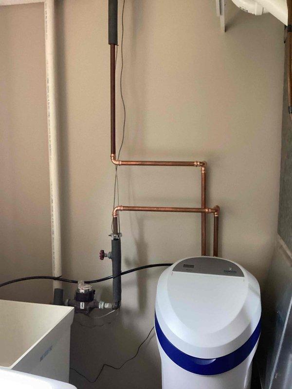 Responded to service call regarding customer-supplied water softener installation where outdoor faucets were not bypassing the system, resulting in softened water at exterior spigots. Upon inspection, confirmed that the water softener was plumbed upstream of the outdoor faucet connections, preventing hard water delivery to exterior hose bibs as desired. Provided repair estimates to reconfigure the plumbing system to properly bypass the softener for outdoor water access.