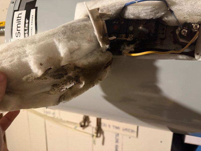 Responded to water heater overheating and leaking issue. Upon inspection, discovered failed temperature and pressure relief valve, pinhole leak in tank jacket above thermostat location, and completely burned out thermostat. Internal insulation showed water saturation from pressure relief valve discharge. Unit was originally installed under warranty and determined to be defective. Documented all damage with photographs showing frost buildup on failed thermostat and overall unit condition. Confirmed water heater qualifies for warranty replacement. Scheduled installation of new 50-gallon residential water heater and replacement of shut-off valve located after pressure tank to ensure proper system operation and safety compliance.