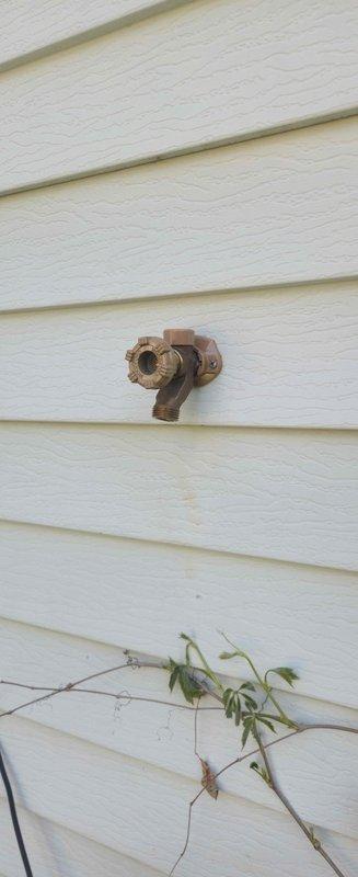 Responded to emergency call for burst pipe at exterior hose bibb connection. Upon arrival, identified severely corroded and split spigot with active water leak. Accessed pipe connection through interior wall opening to assess full extent of damage. Shut off water supply, removed failed spigot assembly, and installed new frost-free hose bibb with proper sealing. Tested new fixture for proper operation and verified no leaks at connection points.
