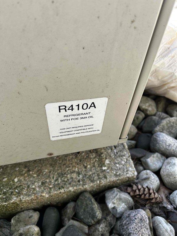 Performed annual AC tune-up on 23-year-old R410A system. Diagnosed no-call condition at thermostat; jumped thermostat to verify AC operation. Inspected indoor unit, flushed condensate drain, and tested blower capacitors—discovered dual 10µF capacitors (totaling 20µF) with one reading 7.5µF and the other near zero. Cleaned outdoor condenser coil and evaluated outdoor capacitors; fan capacitor tested weak, compressor capacitor aged but functional. Verified system pressures and operation. Replaced failed indoor blower capacitors, weak outdoor fan capacitor, and faulty thermostat. Configured new thermostat as heat pump to prioritize hot water fan coil operation before auxiliary electric heat engages. Tested and confirmed proper heating and cooling operation upon completion.