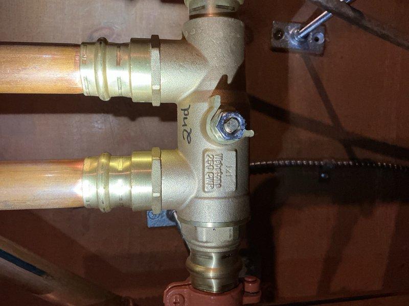 Responded to service call for leaking shut-off valve on recently installed boiler system. Upon arrival, homeowner reported intermittent water leakage from valve handle that had not reoccurred during inspection. Documented existing plumbing configuration including brass manifold assembly with PEX connections and Webstone gas valve installation. Due to intermittent nature of leak and age of components, photographed affected area and submitted parts order for replacement shut-off valve and associated fittings. Recommended replacing entire section of supply line along with shut-off valve to ensure long-term reliability and prevent future leakage issues.