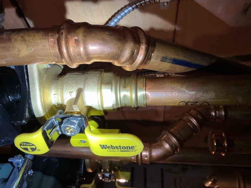 Responded to service call for leaking shut-off valve on recently installed boiler system. Upon arrival, homeowner reported intermittent water leakage from valve handle that had not reoccurred during inspection. Documented existing plumbing configuration including brass manifold assembly with PEX connections and Webstone gas valve installation. Due to intermittent nature of leak and age of components, photographed affected area and submitted parts order for replacement shut-off valve and associated fittings. Recommended replacing entire section of supply line along with shut-off valve to ensure long-term reliability and prevent future leakage issues.