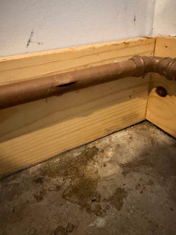 Responded to emergency call for burst copper pipe in garage. Upon inspection, identified frozen and split copper line approximately one inch in diameter serving exterior spigot, with damage extending to boiler drain connection. Removed approximately three feet of compromised copper piping showing severe frost damage and corrosion. Installed new copper pipe section with proper fittings and joints, ensuring secure connections at both termination points. Tested system for leaks and verified proper water flow to exterior spigot and boiler drain. All connections soldered and pressure-tested to code specifications.