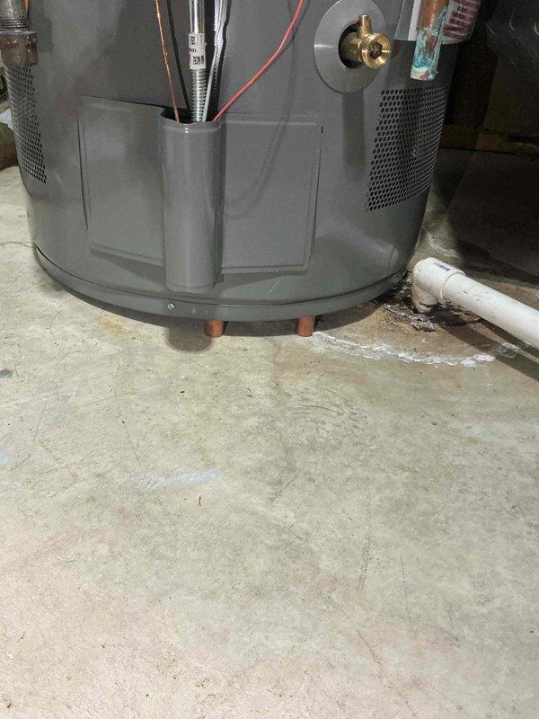 # Tanked Water Heater Installation Support Completion

Completed follow-up appointment for 12-4 tanked water heater installation to address inadequate support system. Upon initial installation, a temporary pipe had been left in place to support the water heater unit, which required replacement with a permanent solution to prevent structural failure and ensure code compliance.

Removed the temporary support pipe that had been holding up the water heater. Fabricated and installed new copper pipe supports positioned vertically beneath the unit to serve as permanent standing feet. The copper pipe configuration was specifically designed to maintain structural integrity over time, preventing the material from squishing or ovaling under the sustained weight of the filled water heater tank.

The new support system provides stable, level positioning for the gray tanked water heater unit on the concrete basement floor. The installation includes proper clearance for the brass valve fittings, copp