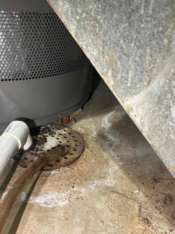 # Tanked Water Heater Installation Support Completion

Completed follow-up appointment for 12-4 tanked water heater installation to address inadequate support system. Upon initial installation, a temporary pipe had been left in place to support the water heater unit, which required replacement with a permanent solution to prevent structural failure and ensure code compliance.

Removed the temporary support pipe that had been holding up the water heater. Fabricated and installed new copper pipe supports positioned vertically beneath the unit to serve as permanent standing feet. The copper pipe configuration was specifically designed to maintain structural integrity over time, preventing the material from squishing or ovaling under the sustained weight of the filled water heater tank.

The new support system provides stable, level positioning for the gray tanked water heater unit on the concrete basement floor. The installation includes proper clearance for the brass valve fittings, copp