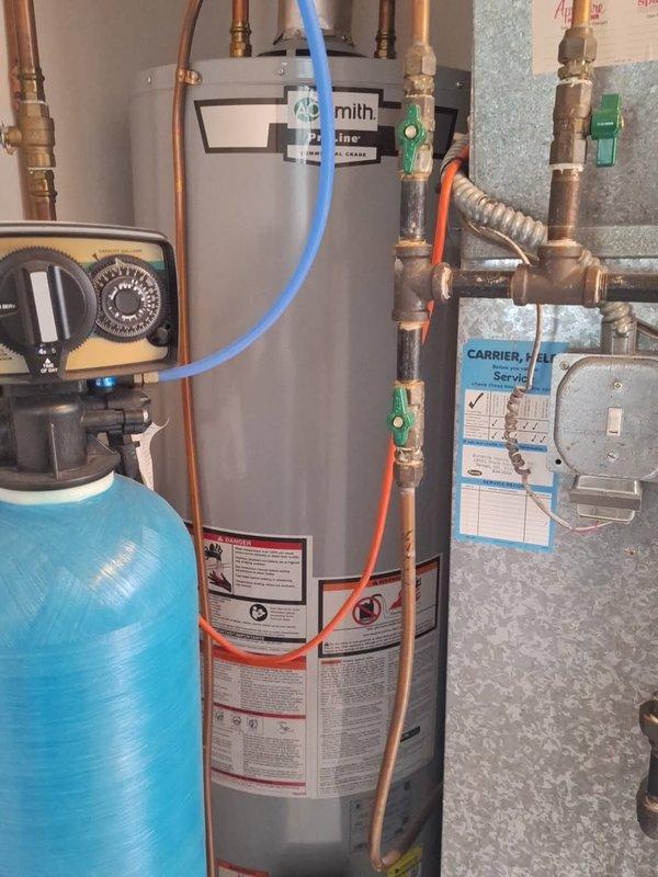 Responded to no hot water call at residential property. Found high limit intake screen on natural gas water heater completely plugged with debris, preventing proper operation. Cleared intake screen and restored hot water functionality. Inspected water heating system including water softener, copper piping, shutoff valves, and all connections to verify proper operation after repair.