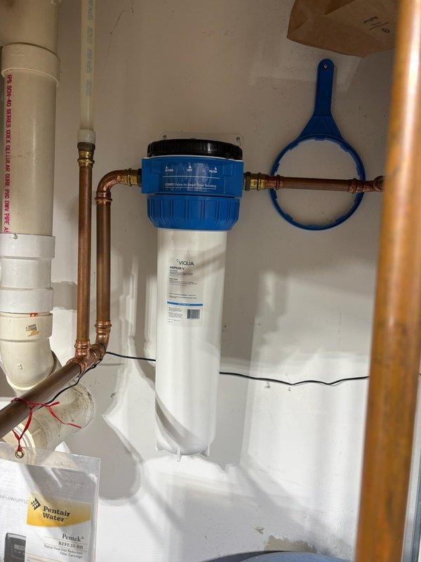 Completed annual maintenance on residential water treatment system. Replaced iron filter cartridge in white cylindrical housing after 14 months of operation. Inspected water softener with digital control head, WaterTrol pressure tank, and associated copper piping connections for proper operation. All equipment functioning within normal parameters. System returned to service.
