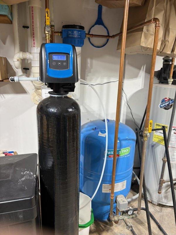 Completed annual maintenance on residential water treatment system. Replaced iron filter cartridge in white cylindrical housing after 14 months of operation. Inspected water softener with digital control head, WaterTrol pressure tank, and associated copper piping connections for proper operation. All equipment functioning within normal parameters. System returned to service.