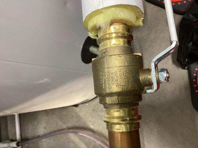 Performed inspection of residential plumbing system to verify pipe sizing, confirming 1-1/2" L copper piping installation. Documented existing HVAC and plumbing configuration including ball valve connections, PVC supply lines, and mechanical equipment layout. Provided consultation regarding electronic anode rod installation options for water heater system.