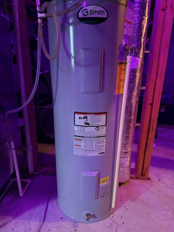Responded to service call for 10-year-old electric water heater evaluation. Upon arrival, inspected 40-gallon AO Smith electric water heater unit located in basement utility area. Assessed overall condition of unit, connections, and surrounding installation. Documented equipment with photographs showing water heater configuration, PEX piping connections, access panels, and manufacturer specification labels. Provided estimate for water heater replacement based on age and condition of existing unit.