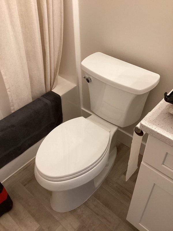 Responded to water leak at back of toilet tank that persisted despite previous seal replacements. Upon inspection, identified that existing 14-inch elongated toilet was incompatible with the rough-in measurement. Flange measurement confirmed 10-inch rough-in rather than standard 12-inch configuration. Removed old toilet and observed corroded, rusted flange showing signs of long-term water exposure and deterioration. Replaced existing oversized toilet with properly sized 10-inch rough-in elongated toilet to match actual flange positioning and bathroom space constraints. Installed new unit, verified proper seal and mounting, tested flush operation, and confirmed no leakage from tank or base connections.