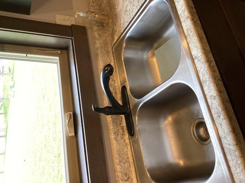 Responded to water leak complaint under kitchen sink at residential property. Upon inspection, identified garbage disposal as source of leak. Removed failed garbage disposal unit and installed new sink basket strainer assembly in double-basin stainless steel sink. Verified all drain connections were properly sealed and tested system for leaks. No further water intrusion detected upon completion.