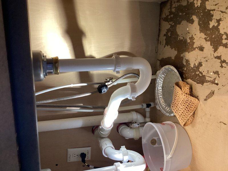 Responded to water leak complaint under kitchen sink at residential property. Upon inspection, identified garbage disposal as source of leak. Removed failed garbage disposal unit and installed new sink basket strainer assembly in double-basin stainless steel sink. Verified all drain connections were properly sealed and tested system for leaks. No further water intrusion detected upon completion.