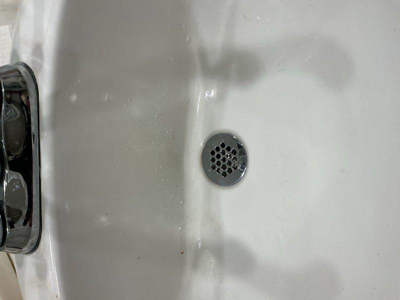 Responded to a bathroom sink drain obstruction. Upon arrival, found the pop-up assembly completely clogged and preventing drainage. Removed the existing pop-up assembly and installed a grid strainer style drain as a replacement to address recurring drainage issues. Performed three full-basin water tests to verify proper drainage and flow rate. Conducted thorough leak inspection of all connections with no leaks detected. System restored to full functionality.