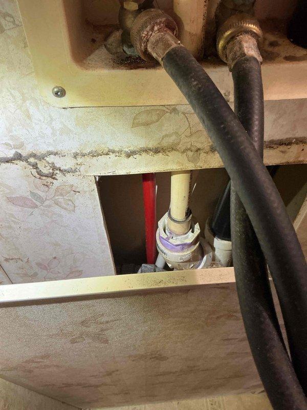 Responded to service call for washing machine shut-off valve issue. Upon inspection, discovered both hot and cold water shut-off valves at the washer box were severely corroded and inoperable, preventing safe installation or connection of washing machine supply lines. The washer box assembly showed significant deterioration with visible water staining, discoloration, and corrosion around valve penetrations, indicating prolonged moisture exposure and age-related degradation. 

Documented existing conditions with photographs showing corroded brass fittings, deteriorated mounting plate, and compromised cabinet structure. Due to the extent of corrosion and inability to operate existing valves, provided customer with detailed bid for complete washer box replacement, including new shut-off valves, mounting assembly, and necessary connections to restore proper washing machine water supply functionality.