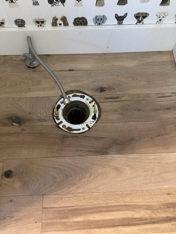 Completed reset and reinstallation of toilet and pedestal sink in powder room. Upon inspection, discovered the toilet flange was positioned 1/2" below the finished floor level, which would have compromised the seal and stability of the fixture. Installed appropriate flange spacer to bring the mounting surface flush with the floor plane, ensuring proper alignment and secure attachment. Successfully set both the toilet and pedestal sink, restoring full functionality to the fixtures with proper sealing and secure mounting.