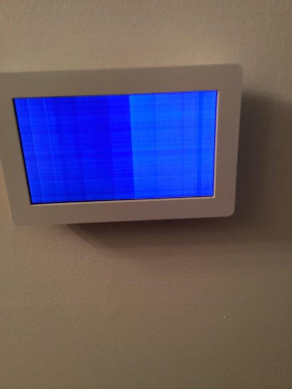 Responded to service call for malfunctioning Lennox thermostat with inoperable display screen showing scrambled blue vertical bands. Diagnosed faulty thermostat unit and successfully replaced with new unit, restoring proper HVAC system control and functionality.