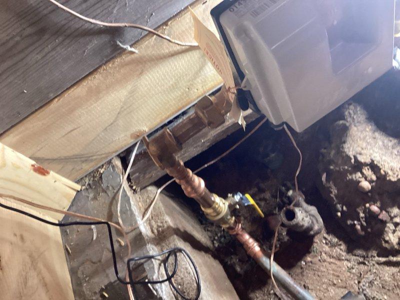 Responded to service call for water meter replacement coordination with municipal water authority. The existing shut-off valve before the meter required replacement to allow the city to install new meter. Coordinated water shut-off scheduling with municipality. Removed existing shark bite fittings on both sides of the water meter. Cut out two shark bite fittings and installed a new three-quarter inch ball valve on the house side of the meter. Replaced outdated shark bite connections with proper fittings to meet code requirements and ensure reliable long-term performance. Work completed in crawl space utility area with corroded existing copper piping. All connections tested and verified operational upon water service restoration.