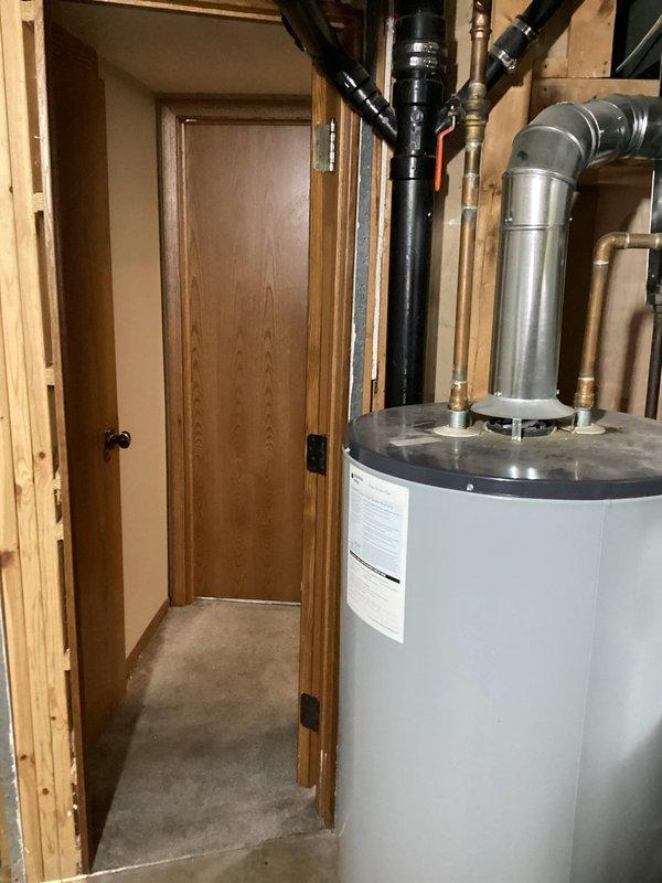 Responded to a water heater leak in a residential basement utility area. Upon inspection, confirmed active leaking from a 12-year-old tanked water heater that had reached the end of its serviceable life. Removed and disposed of the old unit, then installed a new tanked water heater with proper venting and plumbing connections, including copper supply lines and exhaust piping. Tested the new installation for proper operation and verified no leaks at all connection points.