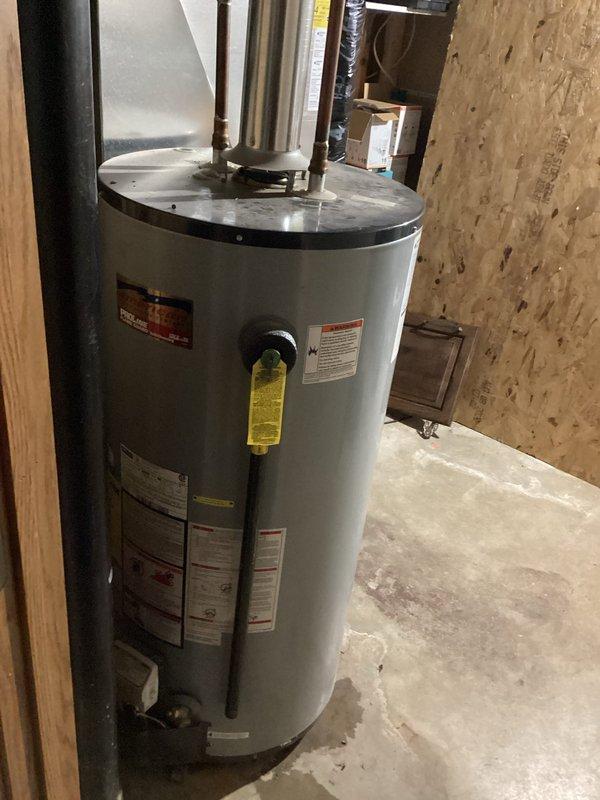Responded to a water heater leak in a residential basement utility area. Upon inspection, confirmed active leaking from a 12-year-old tanked water heater that had reached the end of its serviceable life. Removed and disposed of the old unit, then installed a new tanked water heater with proper venting and plumbing connections, including copper supply lines and exhaust piping. Tested the new installation for proper operation and verified no leaks at all connection points.