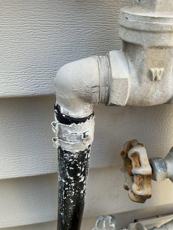 Responded to irrigation system leaks at outdoor spigot assembly with multiple failure points. Upon inspection, identified failed vacuum breaker (model 720-A), corroded gate valve shutoff, and compromised frost-proof hose bib with active leaking at seal points. Water was being temporarily redirected through attached hose to prevent foundation damage. Assessed entire plumbing assembly mounted on exterior wall, noting significant rust and corrosion on metal valve components and deteriorated connection points. Shut off affected components to stop active water loss. Scheduled return visit to replace irrigation vacuum breaker, shutoff valve, and install new frost-proof hose bib assembly to restore proper function and prevent future leaks.