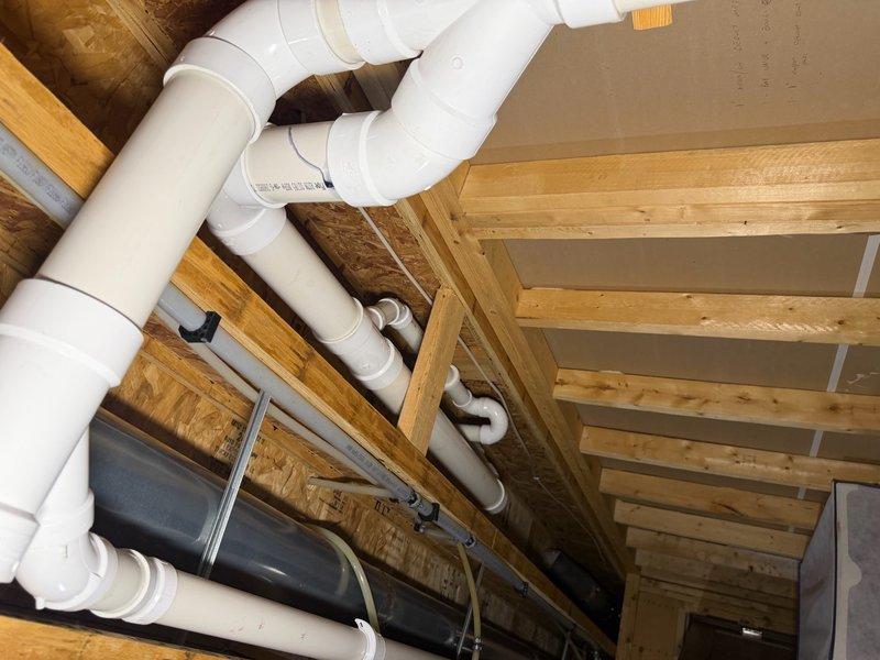 Completed comprehensive plumbing inspection of residential property including evaluation of PVC drainage system infrastructure in crawl space and water heater installation in utility area. All plumbing components, pipe connections, support structures, and water heater operation were visually inspected and documented with photographs for record-keeping purposes.
