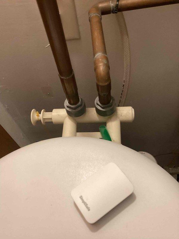 Responded to service call for water softener not using salt and producing no soft water. Upon inspection, found 10-year-old water softener unit with digital control panel showing operational issues. Evaluated system including copper piping connections, shut-off valves, and bypass configuration. Assessed water softener's mechanical and electronic components to determine failure point preventing salt consumption and regeneration cycle. Documented equipment condition with photographic evidence of plumbing connections, control head, and overall system layout. Recommended advisor consultation for comprehensive system evaluation and replacement options due to age and condition of existing unit.