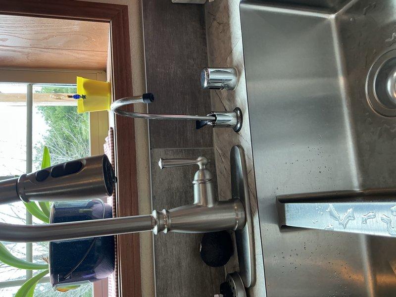 Responded to service call for kitchen sink reinstallation following new countertop installation. Mounted kitchen sink faucet and reverse osmosis faucet to new sink basin. Installed two new basket strainers per customer request. Reconfigured PVC drain assembly to accommodate significantly deeper sink basin, ensuring proper drainage pitch. Corrected previous reverse osmosis discharge line that had been improperly threaded directly into sink drain. Completed all plumbing connections and verified proper operation of both faucets and drainage system.