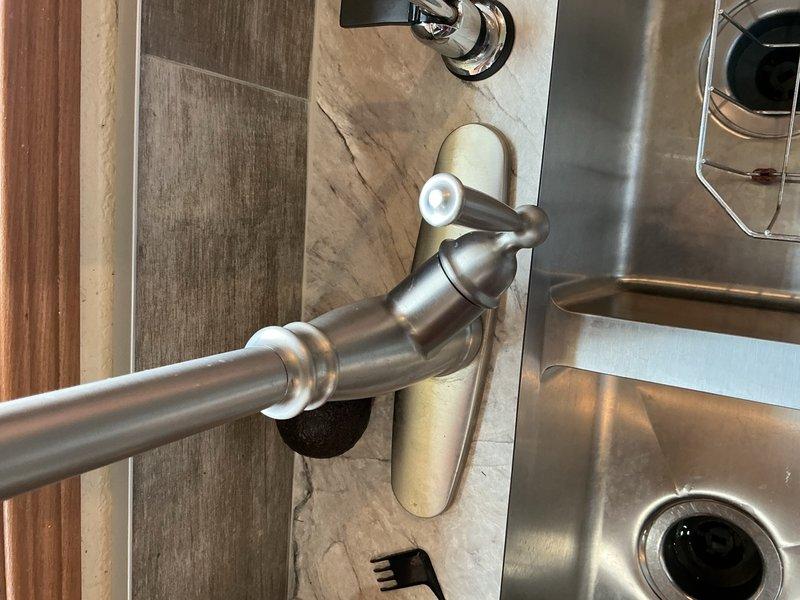Responded to service call for kitchen sink reinstallation following new countertop installation. Mounted kitchen sink faucet and reverse osmosis faucet to new sink basin. Installed two new basket strainers per customer request. Reconfigured PVC drain assembly to accommodate significantly deeper sink basin, ensuring proper drainage pitch. Corrected previous reverse osmosis discharge line that had been improperly threaded directly into sink drain. Completed all plumbing connections and verified proper operation of both faucets and drainage system.