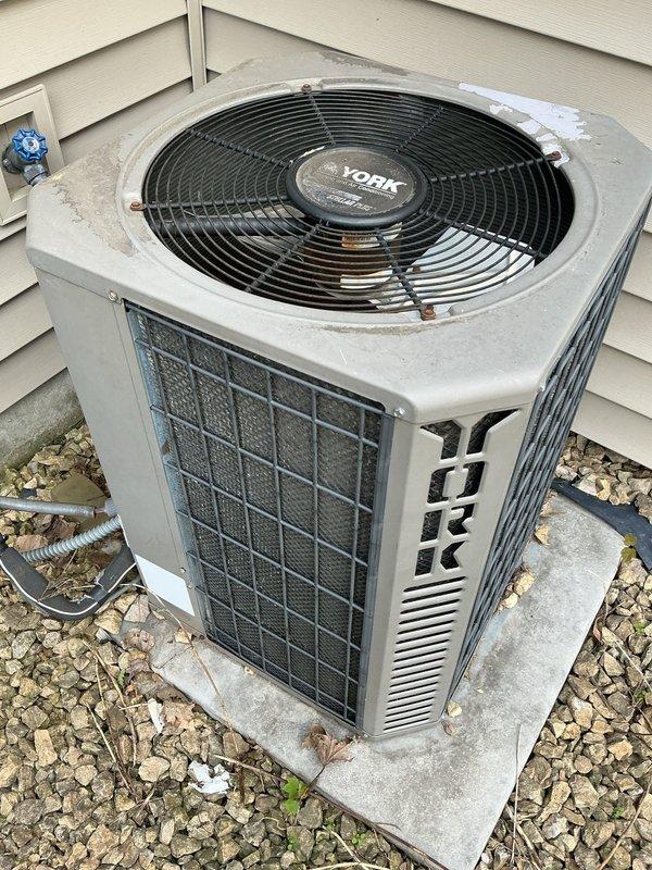 Responded to no cooling call on 22-year-old York R22 air conditioning system. Upon arrival, discovered customer had recently replaced thermostat but failed to connect wiring to outdoor condensing unit, resulting in complete system failure. Diagnosed wiring issue and properly reconnected thermostat wires to restore communication between indoor and outdoor units. Tested system operation and confirmed air conditioning unit now powers on and cycles properly. Noted outdoor condenser coil requires cleaning due to dirt and debris accumulation affecting efficiency. Advised customer of system age, R22 refrigerant phase-out implications, and replacement options. Customer declined replacement recommendations and elected to perform condenser coil cleaning independently. System restored to operational status with proper thermostat wiring configuration.