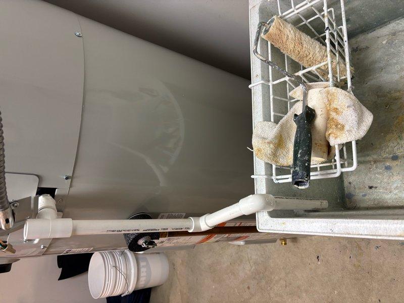 Removed and disposed of existing natural draft water heater, capped 3/8" gas line at furnace and 4" ventilation. Installed Bradford White G2 Series 65-gallon electric hybrid heat pump water heater in new location next to utility sink. Extended 3/4" water inlet and outlet lines to new location and connected to system with code-compliant isolated shut-off valves. Installed condensate line routed to utility sink. Ran dedicated 240V circuit from electrical panel in garage, through accessible attic space, down shared wall into utility room (approximately 40' total run). Performed panel modifications to accommodate new circuit on full panel, installed disconnect adjacent to water heater, completed all wiring connections at panel, disconnect, and water heater. Programmed and configured water heater to specifications. Completed virtual inspection which passed. Verified all connections leak-free and confirmed system operational upon power-up.