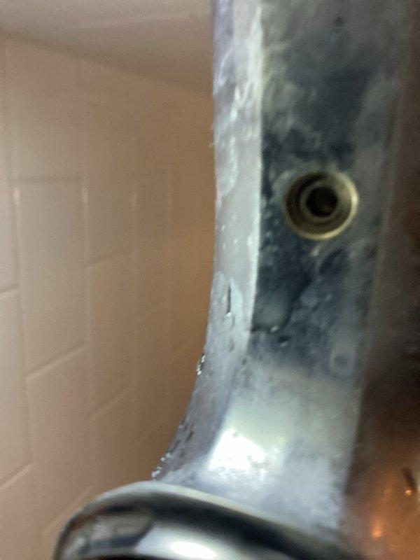Responded to service call for bathroom fixture evaluation and tub spout malfunction. Upon inspection, identified failed diverter mechanism in chrome tub spout causing active leak. The diverter, which controls water flow between the tub spout and showerhead, showed significant deterioration and was no longer functioning properly. Documented existing bathroom configuration featuring white subway tile surround and chrome fixtures. Photographed the leaking tub spout assembly and provided customer with replacement options and estimates for new fixture installation to resolve the diverter failure and restore proper function to the tub and shower system.