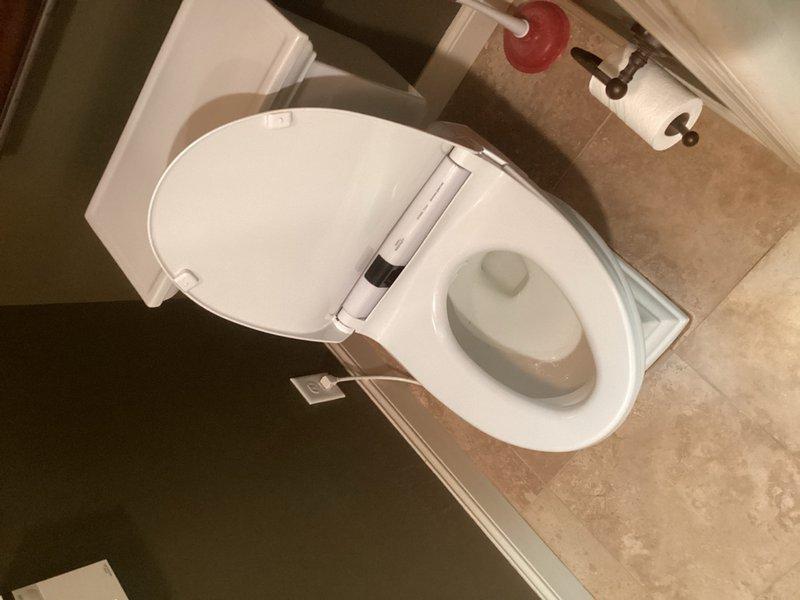 Replaced previously installed elongated toilet seat with original Toto washlet seat to restore heated seat functionality. Removed standard wooden seat and reinstalled washlet unit in primary bathroom. Retrieved replacement Toto toilet seat from warehouse and left with customer for future use. In secondary bathroom, installed customer-supplied washlet seat per request. Verified all washlet operations functioning properly, including bidet spray, air dryer, and heated seat features. Noted reduced water pressure in bidet stream consistent with previous diagnosis. All installations secured and tested for proper operation.