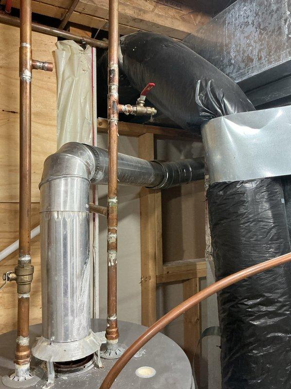 Completed comprehensive plumbing inspection and repairs addressing multiple findings from property inspection report. Installed new main shut-off valve to replace corroded existing valve on water main line entering the structure. Corrected improper water heater venting configuration to meet code requirements and ensure safe exhaust ventilation. Repaired leaking drain assembly under upstairs bathtub fixture. Addressed leak under bathroom sink drain. Assessed corroded copper water main piping showing significant oxidation and deterioration near floor penetration, documenting condition for future repair consideration. Evaluated sump pit water accumulation and confirmed absence of sump pump system. Documented utility sink requiring replacement due to cracked basin. All accessible repairs completed during single service visit, with photographic documentation provided for items requiring municipal coordination or future attention.