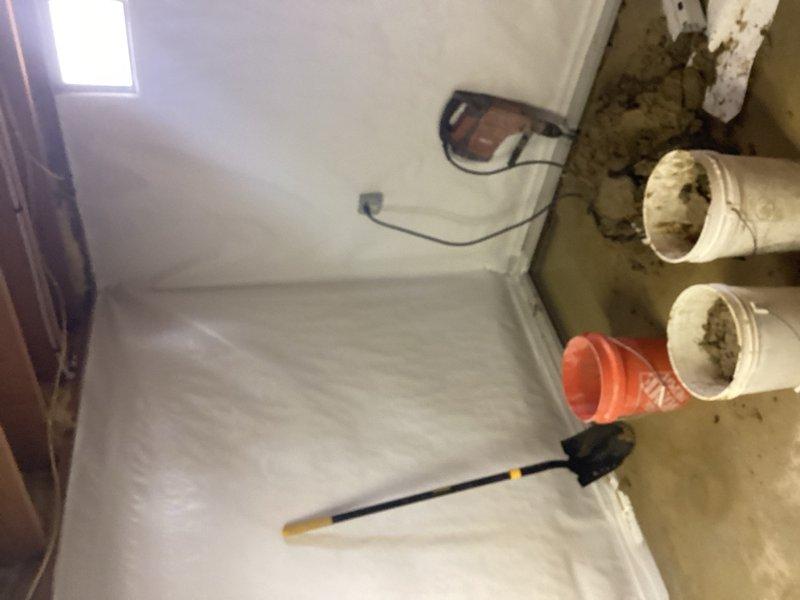 Responded to service call for sump pump adjustment in basement area undergoing renovation. Assessed existing sump pump system and identified discharge configuration concerns. Provided estimate for installation of proper discharge lines for two sump pumps to ensure adequate water removal and prevent basement flooding. Documented current conditions of work area with protective floor coverings in place and exposed wall framing visible during active construction phase.