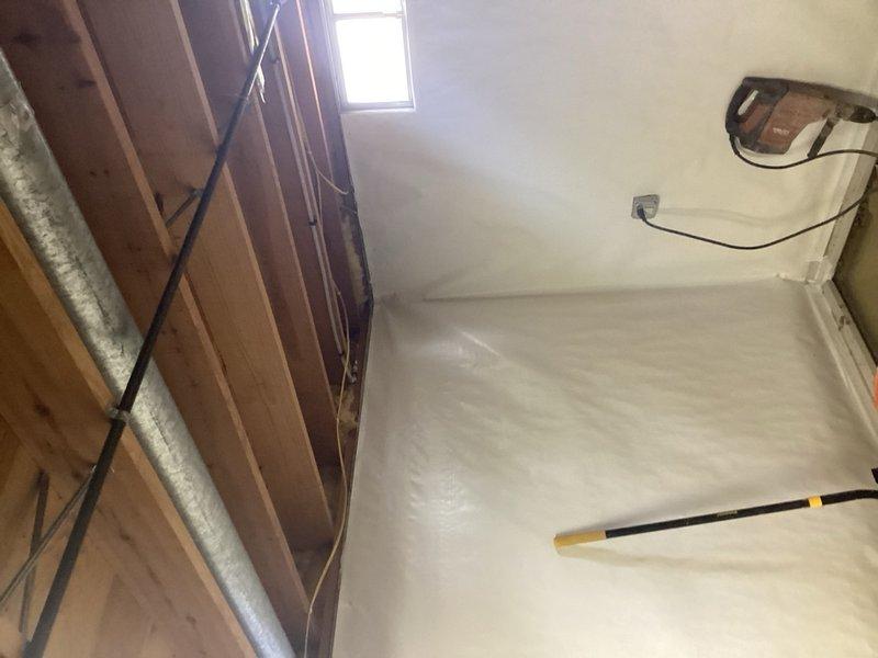Responded to service call for sump pump adjustment in basement area undergoing renovation. Assessed existing sump pump system and identified discharge configuration concerns. Provided estimate for installation of proper discharge lines for two sump pumps to ensure adequate water removal and prevent basement flooding. Documented current conditions of work area with protective floor coverings in place and exposed wall framing visible during active construction phase.