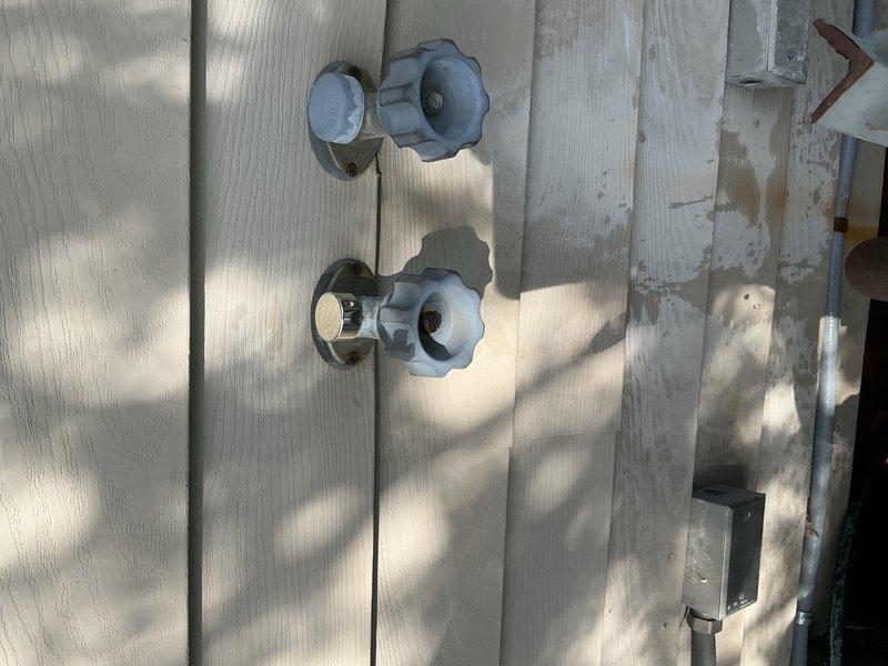 Responded to two leaking outdoor faucets at rear of property. The right-side spigot exhibited a pencil-stream leak and required complete stem rebuild with replacement of all internal components. The left-side faucet showed severe leaking from the aerator, compounded by a garden hose being left connected through winter, causing freeze damage; replaced the aerator assembly. Customer opted for repair over full replacement to avoid interior wall access near occupied living space. Advised ongoing monitoring of both fixtures due to age and condition of existing hardware.